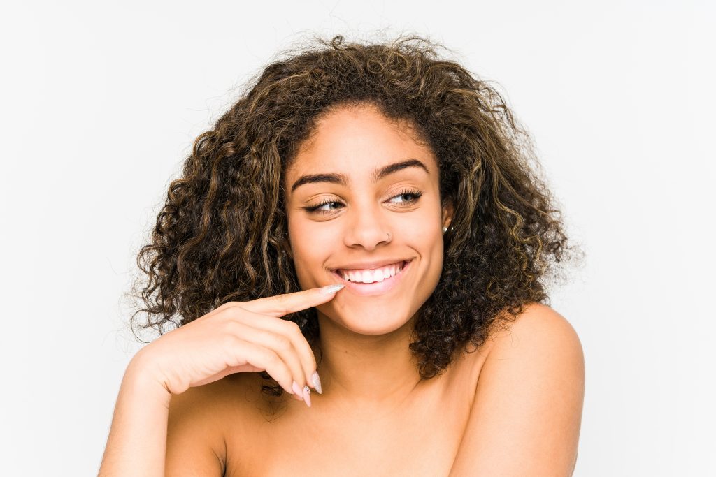 mulher negra feliz dia depois de realizar transição capilar