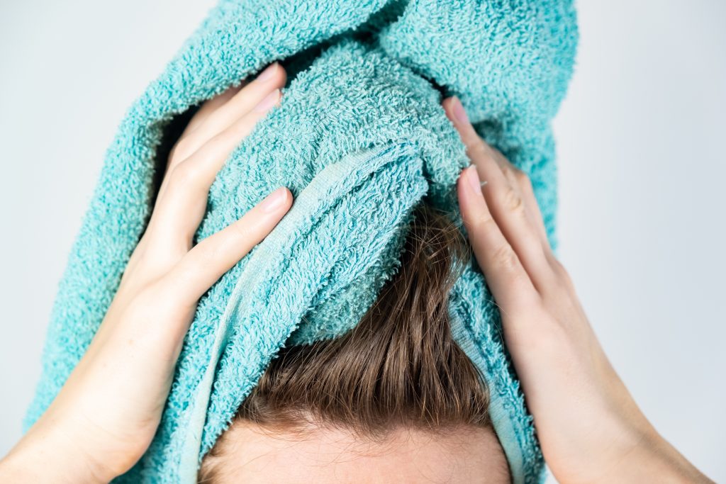 mulher secando os cabelos com toalha de algodão
