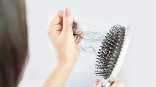 mulher retirando cabelos da escova de cabelo