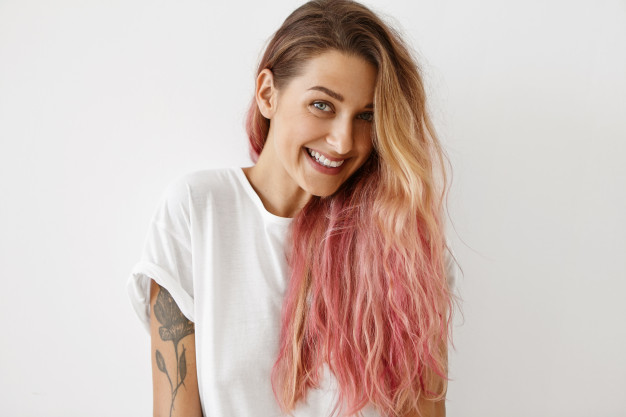 mulher loira com cabelos rosados e tatuagem