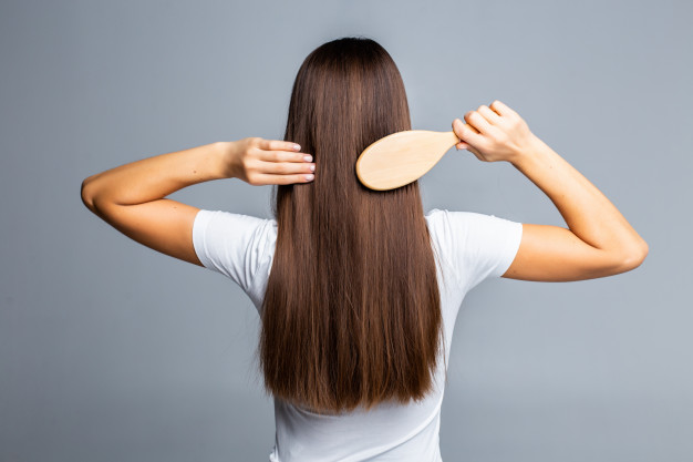 Mão feminina segurando secador de cabelo, isolado no branco