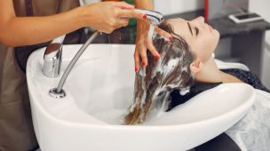 cabelereira lavando cabelo de cliente